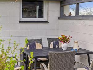 a black table with chairs and a vase of flowers at Holiday Home Aletha - 300m to the fjord by Interhome in Snedsted +15 photos
