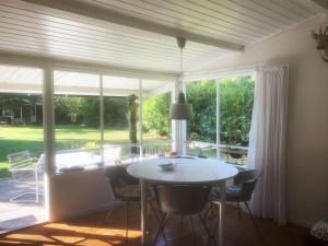 a dining room with a table and chairs and a large window at Holiday Home Elisa - 600m from the sea by Interhome in Gedser