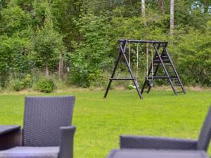 a swing set in the grass with two chairs at Holiday Home Anett - 375m from the sea by Interhome in Fårevejle