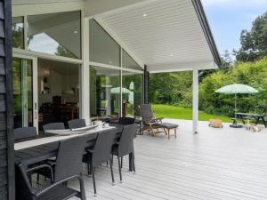 a patio with a table and chairs on a deck at Holiday Home Anett - 375m from the sea by Interhome in Fårevejle