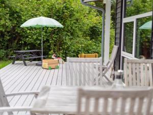 a deck with a picnic table and an umbrella at Holiday Home Anett - 375m from the sea by Interhome in Fårevejle