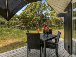 a table and chairs on a porch with a view at Holiday Home Ubbe - 800m from the sea by Interhome in Fanø