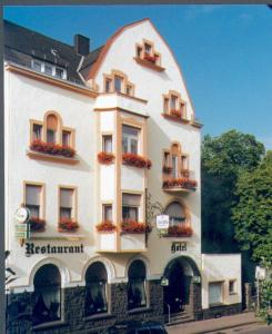 un gran edificio blanco con cajas de flores. en Hotel-Restaurant "Zum Alten Fritz" en Mayen