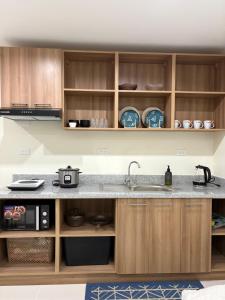 a kitchen with a sink and wooden cabinets at Chic Condo with Gym and Pool Access in Mactan