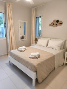 a bedroom with a large bed with towels on it at Stay and Nest Casa Nola Elegant Modern Bungalow, Pool & Sea Location, Paphos in Chlorakas