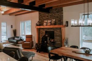 Una sala de estar con chimenea y una mesa y sillas. en Spa Firepit & Nature - Chalet de la Colonie, en Val des Monts