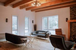 Una sala de estar con un sofá, una mesa y sillas. en Spa Firepit & Nature - Chalet de la Colonie, en Val des Monts