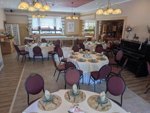 a dining room with tables and chairs and a piano at Hotel & Restaurant Rösselsquelle in Ludwigswinkel