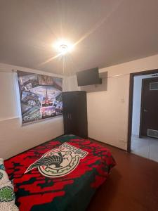 a bedroom with a bed with a painting on the wall at Universal Play in Bogotá