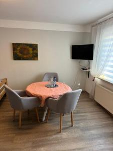 a dining room with a table and chairs and a television at Monteurswohnung Rothentor4 in Steffin