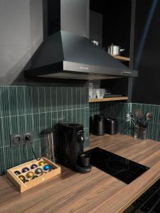 a kitchen with a stove and a hood over a counter at SV- Le Secret Marseillais Love room in Marseille