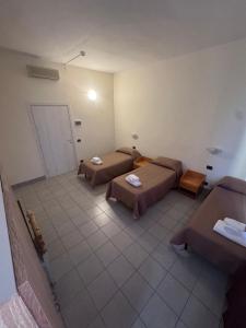 a room with two beds and tables in it at Residence H5 in Piacenza