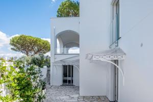 an external view of a white house with an archway at Villa Coralia Sorrento, Luxury Suite in Amalfi Coast, Italia in Sorrento