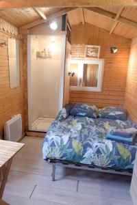 a bedroom with a bed in a wooden room at La Boisselée in Saint-Dyé-sur-Loire