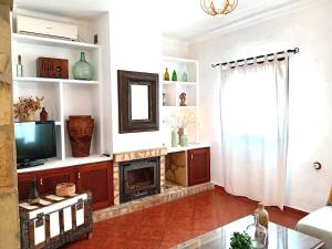 a living room with a fireplace and a television at Apartamentos María Gaviota in Prado del Rey