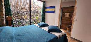 a bedroom with a blue bed and a window at Casas Floeca in Jardim do Mar +17 photos