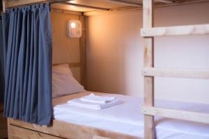 een stapelbed in een tiny house met een blauw gordijn bij Dream Hostel Zaporizhia in Zaporozhye