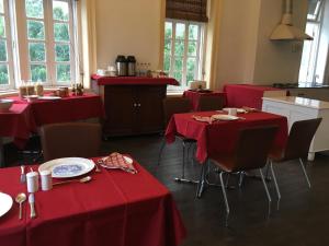 a restaurant with red tables and chairs in a room at The Harrington Residency in Kolkata