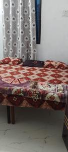 a bed with a quilt on it in a room at Madhav home stay in Prayagraj
