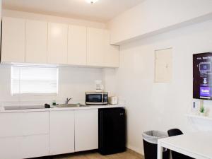 a kitchen with white cabinets and a microwave at Boulevard Park IV 207 in Mayaguez