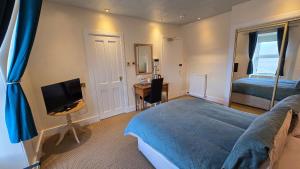 a bedroom with a bed and a television and a desk at The Pitfour Arms Hotel in Mintlaw