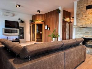 Un sofá grande en una sala de estar con chimenea. en Angel's Apartment, en Banská Bystrica