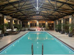 a large swimming pool in a large building with at Schuchmann Wines Château,Villas & SPA in Tʼelavi