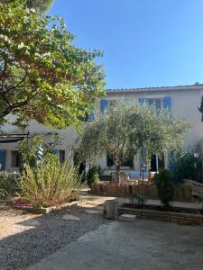 Un patio con árboles y un edificio. en Le colibri bleu, en Argeliers 103 fotos más