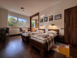 Un dormitorio con dos camas y un escritorio. en Angel's Apartment, en Banská Bystrica