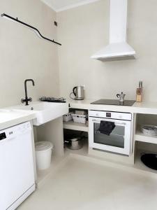 a white kitchen with a sink and a stove at Casa Rofe in Playa Honda