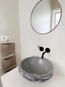 a bathroom sink with a round mirror on the wall at Casa Rofe in Playa Honda