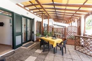Habitación con mesa y sillas en el patio en Villa Peonia - Salento Reservation, en Isola Pazzi