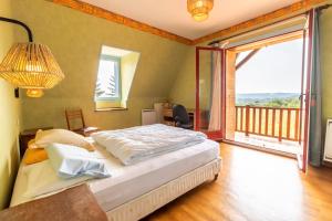Un dormitorio con una cama y un balcón. en Résidence musicale de Panissal, en Montignac