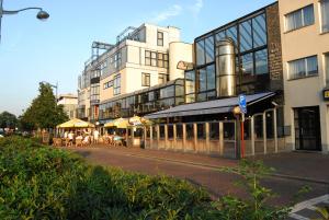 een gebouw met tafels en parasols in een stadsstraat bij Hotel De Swaen in Herentals