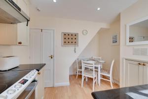 eine Küche und ein Esszimmer mit einem Tisch in der Unterkunft Twitten Cottage in Southwold + 4 Fotos