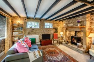 Bankside Cottage في هالتويسل: غرفة معيشة مع أريكة ومدفأة