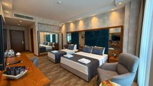 a hotel room with a bed and a living room at Alsancak Prime Hotel Konya in Yazır