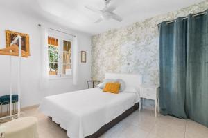 a bedroom with a white bed and a blue curtain at Villa Ojuelos Paraíso Natural in Vega de San Mateo +38 photos