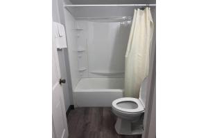 a bathroom with a toilet and a tub and a sink at Capital O Elite Inn & Suites South Holland I 94 in South Holland +31 photos