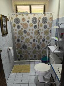 Un baño con cortina de ducha y un inodoro. en Pacayitas El Camino House, en Turrialba 30 fotos más