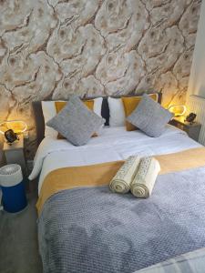 a bedroom with a bed with two remote controls on it at Bavelle Bilston Urban Village in Bilston