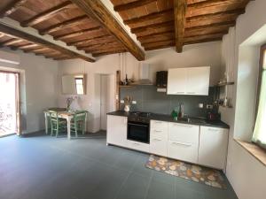 a kitchen with white cabinets and a table in it at Transito divino Gaiole in Gaiole in Chianti