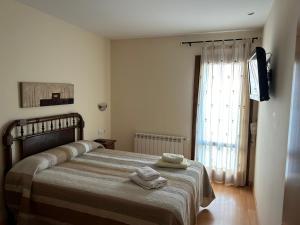 a bedroom with a bed with two towels on it at Casa Rural Barranco in Bielsa