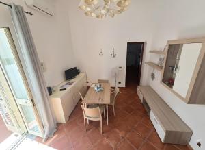 a living room with a table and a desk at La casa del Villaggio in Torre Faro