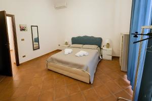 a bedroom with a bed with towels on it at La casa del Villaggio in Torre Faro