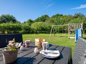 Una mesa de picnic con una cesta de pan y un columpio. en Holiday Home Abbo - 750m from the sea by Interhome, en Glesborg