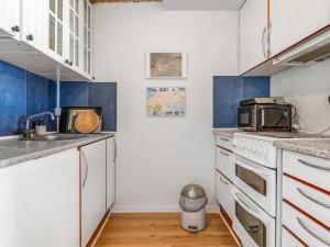 a small kitchen with white cabinets and a sink at Apartment Didrik - 2km from the sea by Interhome in Skagen