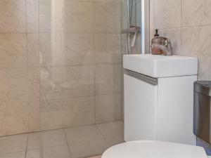 a bathroom with a shower with a toilet and a sink at Apartment Didrik - 2km from the sea by Interhome in Skagen +13 photos