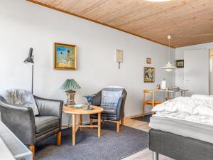 a bedroom with a bed and chairs and a table at Apartment Didrik - 2km from the sea by Interhome in Skagen