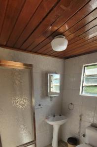 a bathroom with a sink and a toilet and a window at Recanto da Morgana-Lofts bem equipados, conforto e piscina grande in Teresópolis +22 photos